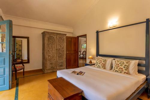 a bedroom with a large bed with a large headboard at Beachside Bliss Villas Candolim 10 min walk from Sinquerim Beach in Sinquerim