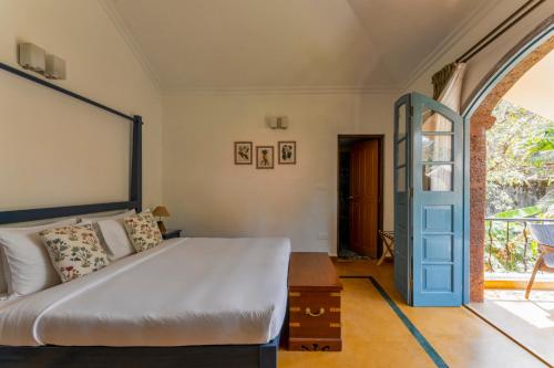a bedroom with a bed with a blue door at Beachside Bliss Villas Candolim 10 min walk from Sinquerim Beach in Sinquerim
