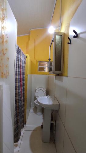 ein kleines Bad mit einem Waschbecken und einem WC in der Unterkunft Quartos simples e aconchegantes na orla de Itaparica in Itaparica Town