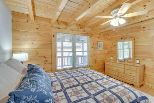 Cozy North Carolina Cabin - Deck, Grill and Fire Pit في Bostic: غرفة نوم بسرير ومروحة سقف