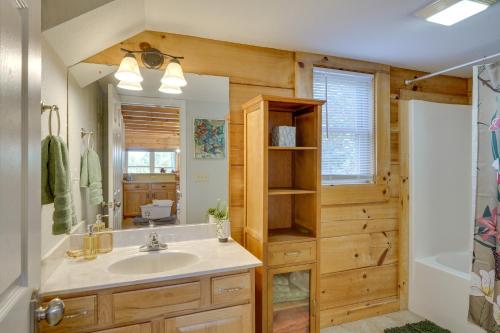 a bathroom with a sink and a mirror and a tub at Cozy North Carolina Cabin - Deck, Grill and Fire Pit in Bostic