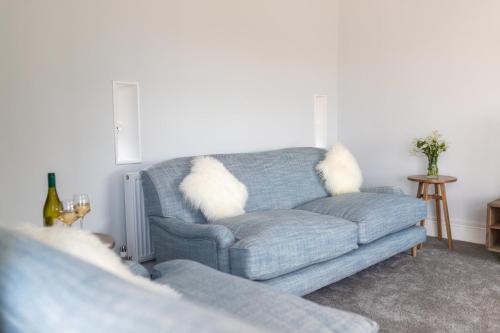 a living room with a gray couch with white pillows at La Roche-Barn with hot tub on the Welbeck estate in Holbeck
