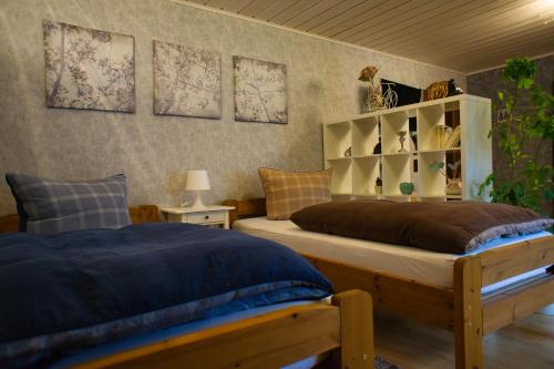 a bedroom with two beds and a book shelf at Gemütliche Wohnung mit Neckarblick in Eberbach