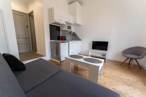 un salon avec un canapé et une cuisine dans l'établissement Nice Plein Centre STUDIO 1 avec BALCON, à Nice