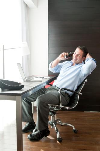 a man sitting at a desk talking on a cell phone at Fiesta Inn Toluca Tollocan in Toluca
