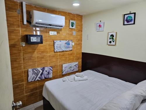 a bedroom with a bed and a tv on a wall at 24Seven Guesthouse in Kuala Lumpur