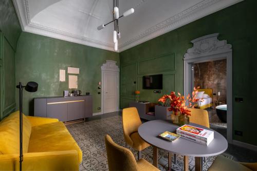 a living room with green walls and a table and chairs at VIS Urban Suites&Spa in Bari