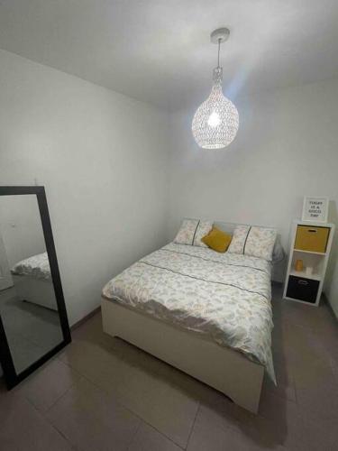 a bedroom with a bed and a mirror and a light at Appart T2 proche Aéroport Roissy in Tremblay En France