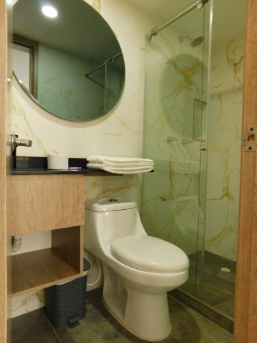 a bathroom with a toilet and a glass shower at HOTEL MX BOGOTA in Bogotá
