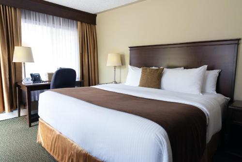 a hotel room with a large bed and a desk at Aurora Inn in Kingston
