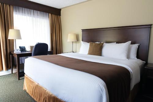 una camera d'albergo con un grande letto e una scrivania di Aurora Inn a Kingston