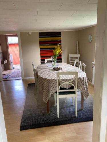uma sala de jantar com uma mesa e cadeiras com um vaso sobre ela em Bokskog, sjö, MTB, Gekås Varberg em Rolfstorp