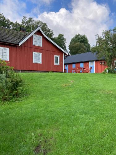 un granero rojo con un césped verde delante de él en Bokskog, sjö, MTB, Gekås Varberg en Rolfstorp