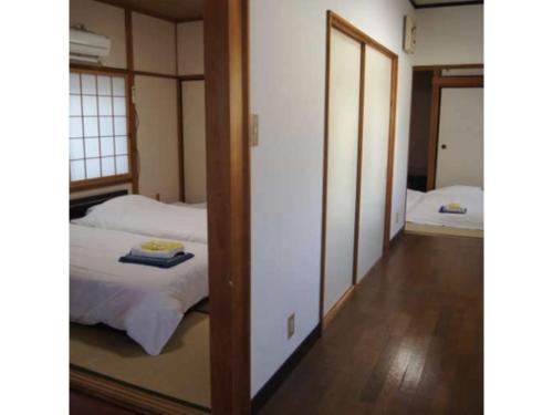 Kansai Airport Spa Hotel Garden Palace - Vacation STAY 72631v في إيزوميسانو: غرفة نوم بسريرين ومرآة