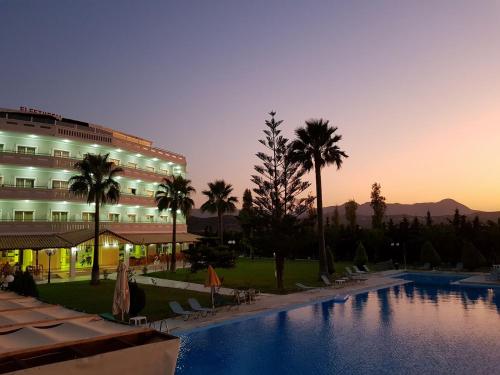 a hotel with a swimming pool in front of a building at Regina Hotel in Kissamos