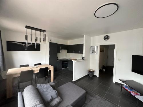 una sala de estar con un sofá y una mesa en Appartement Guillaume, en Blankenberge