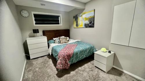a bedroom with a bed and a dresser and a clock at Fully Separate & Private Guest Suite in Edmonton