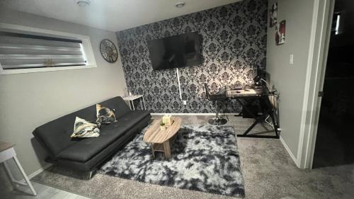 a living room with a black couch and a table at Fully Separate & Private Guest Suite in Edmonton