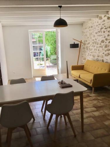 un salon avec une table, des chaises et un canapé dans l'établissement Maison charme 5 min des remparts, à Avignon
