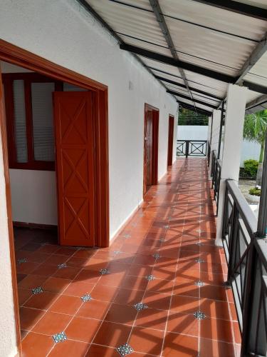 a corridor of a house with a red tiled floor at Quinta Maria in Fusagasuga