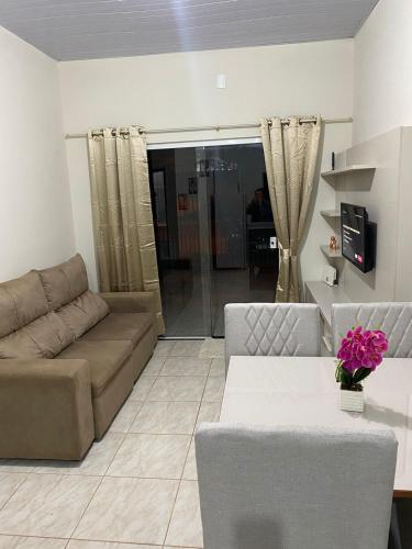 ein Wohnzimmer mit einem Sofa und einem Tisch in der Unterkunft Casa confortável na terra das cataratas in Foz do Iguaçu