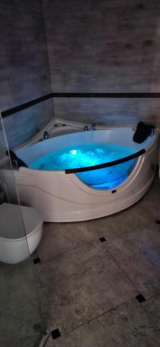 El baño incluye bañera con agua azul. en Sea romantic 26th floor with Jacuzzi, en Klaipėda