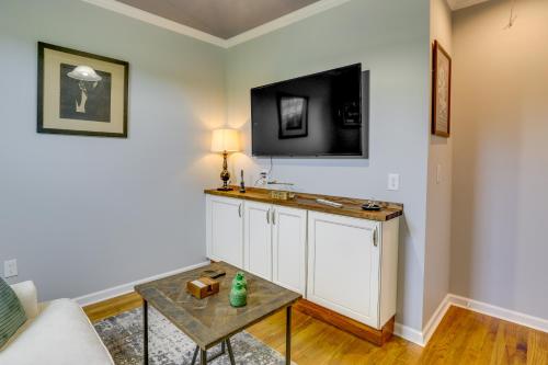 ein Wohnzimmer mit einem Tisch und einem TV an der Wand in der Unterkunft Inviting Quincy Cottage Walk to Historic Downtown in Quincy