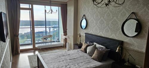 1 dormitorio con cama grande y ventana grande en Sea romantic 26th floor with Jacuzzi, en Klaipėda