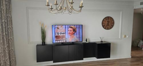 sala de estar con TV de pantalla plana en una pared blanca en Sea romantic 26th floor with Jacuzzi, en Klaipėda