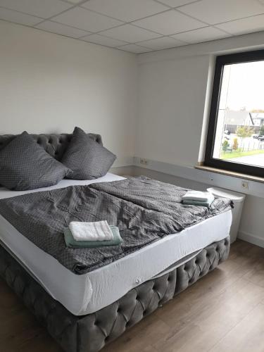 una cama grande en una habitación con ventana en Bataver, en Neuss