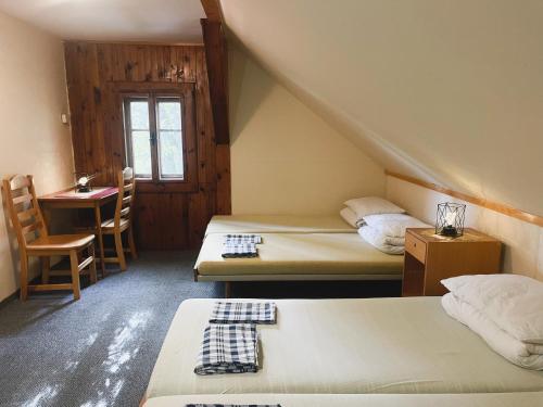 Habitación con 2 camas, mesa y escritorio. en Horská chata Mamut, en Dolní Malá Úpa