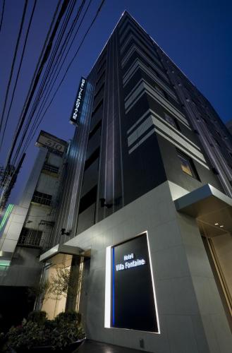 a tall building with a sign in front of it at Villa Fontaine Tokyo Shinjuku in Tokyo