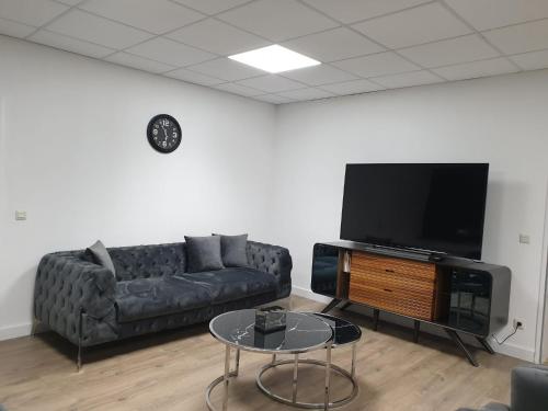 Una sala de estar con un sofá y un televisor de pantalla plana. en Bataver, en Neuss