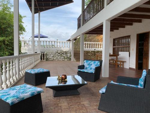 een patio met stoelen en een tafel op een veranda bij Hermosa Cabaña en Isla privada Prado Tolima in Prado