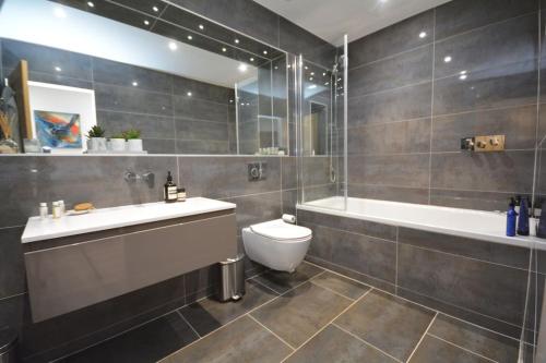 La salle de bains est pourvue d'une baignoire, de toilettes et d'un lavabo. dans l'établissement Detached modern home with stunning views, à Buckinghamshire