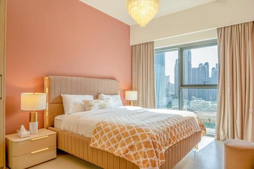 a bedroom with a bed and a large window at FIRST CLASS 2BR with full BURJ KHALIFA view in Dubai