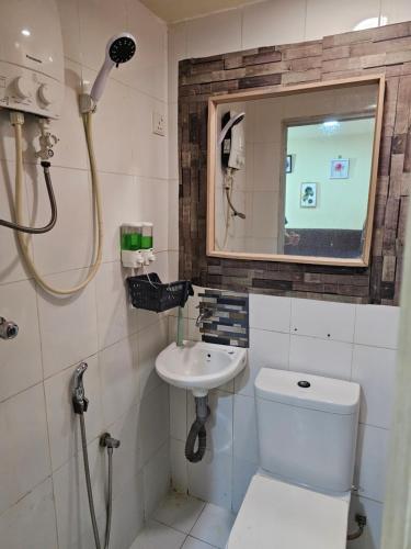 uma casa de banho com um chuveiro, um WC e um lavatório. em 24Seven Guesthouse em Kuala Lumpur