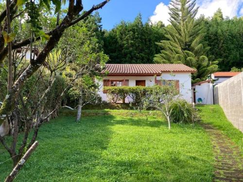 a house in the middle of a yard at Chalet da Eirinha in Furnas