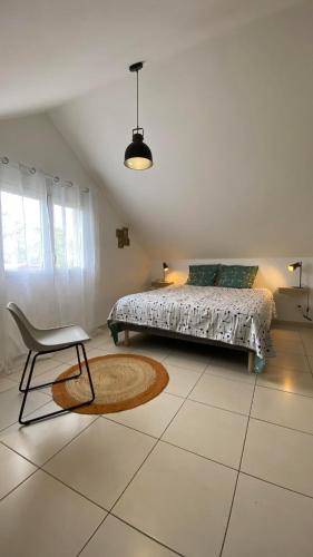 a bedroom with a bed and a chair and a rug at L'anthurium in La Plaine des Palmistes