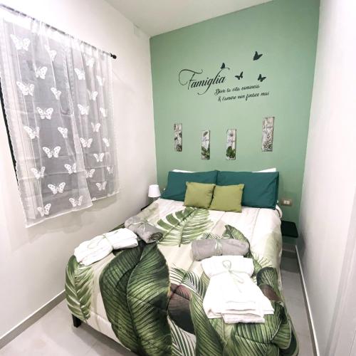 ein Schlafzimmer mit einem Bett mit einer grünen Wand in der Unterkunft All-in in Neapel