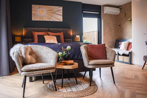 ein Wohnzimmer mit 2 Stühlen und einem Sofa in der Unterkunft DreamZzz Boutique B&B Kaatsheuvel in Kaatsheuvel