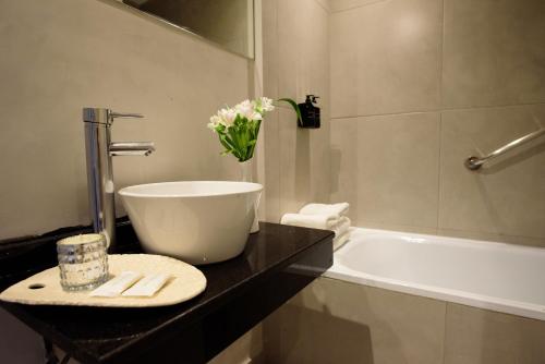uma casa de banho com uma banheira branca, um lavatório e uma banheira. em M Concept Hotel em Buenos Aires