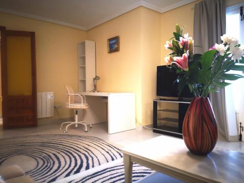 a living room with a vase of flowers on a table at Spacious apartment La Mata pool&beach in Torrevieja