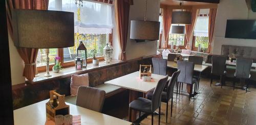 un restaurante con mesas, sillas y ventanas en Pension Gasthof Gaistal, en Leutasch
