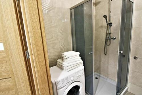 コウォブジェクにあるBliżej Morza Deluxe Apartmentyのバスルーム(シャワー、洗濯機付)