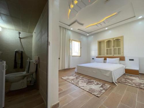 a bedroom with a bed and a bathroom with a toilet at Villa ahlam in Essaouira