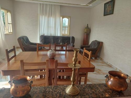 a living room with a wooden table and chairs at Villa ahlam in Essaouira
