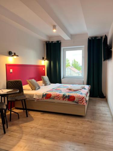 sypialnia z łóżkiem, stołem i oknem w obiekcie 3 Budget Stay Apartments w mieście Zgorzelec
