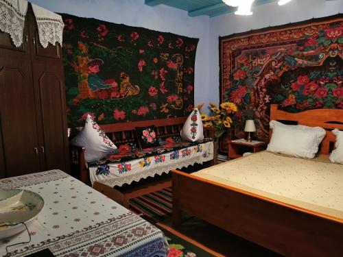 a bedroom with two beds and a tapestry on the wall at La Mădălina in Selemet