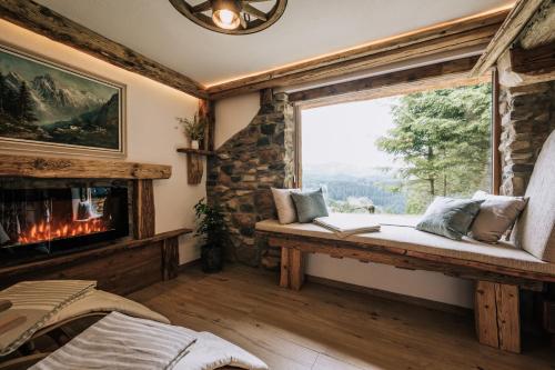 posto a sedere vicino alla finestra in una stanza con camino di Webertonihütte a Bad Sankt Leonhard im Lavanttal